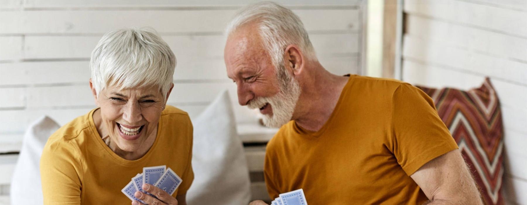 a man and woman sitting at a table playing cards